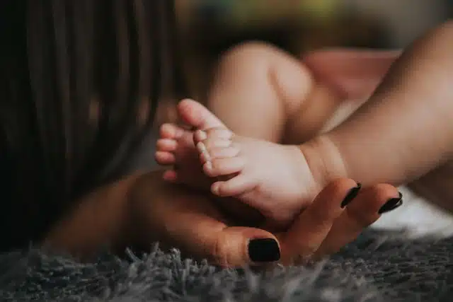 mother holding baby feet - birth story