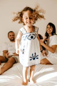parents and baby on bed