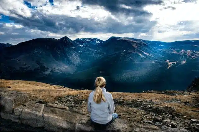 woman sitting before mountains