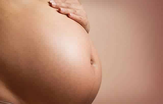 pregnant woman holding her belly -baby movements