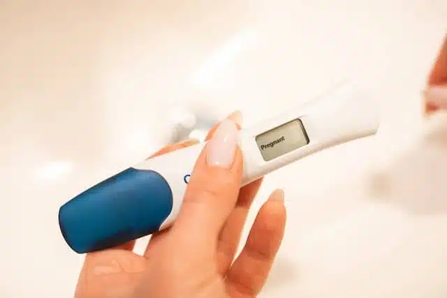 woman holding a positive digital pregnancy test kit